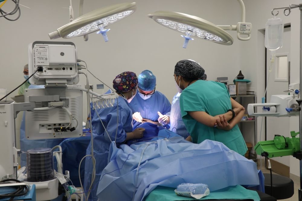 Equipe de cirurgiões trabalhando em conjunto em sala de cirurgia equipada
