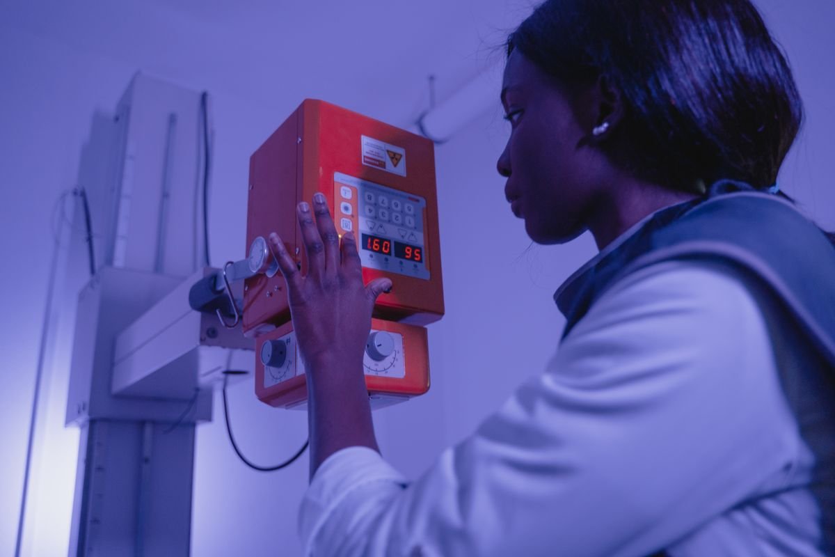 Profissional de radiologia operando equipamento de raio-x em ambiente clínico